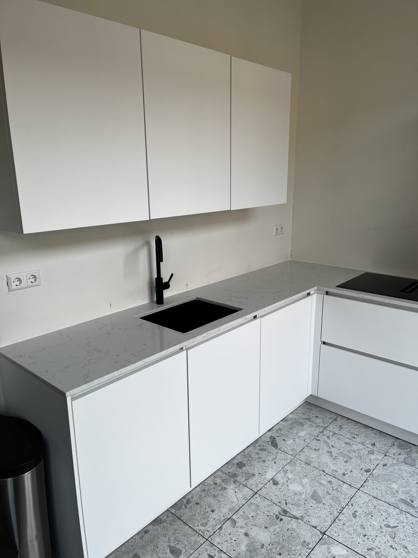Gerenoveerde witte keuken met composiet werkblad in Amsterdam
